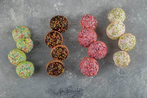 Kleurrijke zoete donuts met hagelslag op donkere achtergrond — Stockfoto
