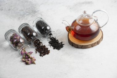 Tahta üzerinde çay olan camdan bir çaydanlık.