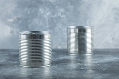 Mermer zemin üzerinde iki metal kutu.