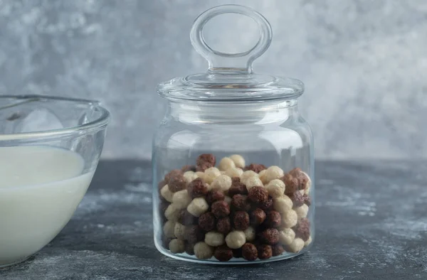 Tarro de vidrio de bolas de cereales y leche sobre fondo de mármol —  Fotos de Stock