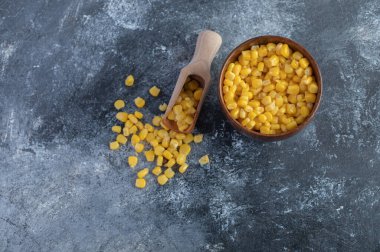 Kaşık ve bir kase tatlı mısır mermer arka planda