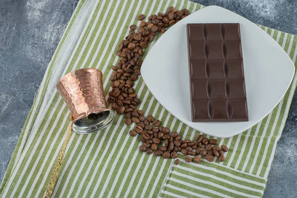 Bar de chocolate com grãos de café em uma toalha de mesa — Fotografia de Stock