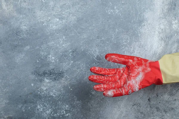 Mano in guanti protettivi su sfondo di marmo — Foto Stock