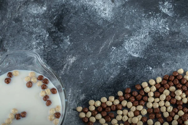 Cuenco de leche fresca con bolas de chocolate sobre fondo de mármol —  Fotos de Stock