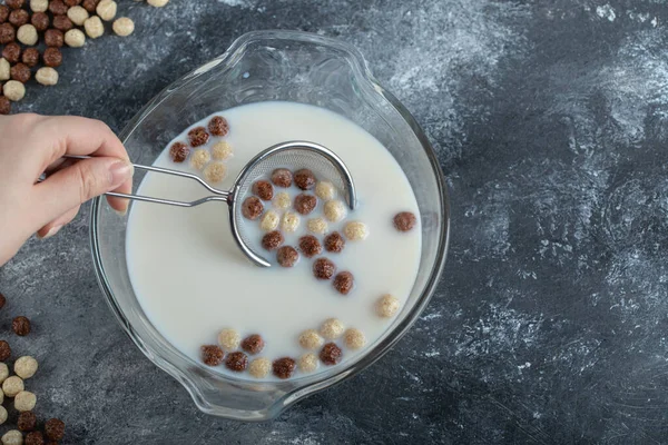 Söta spannmål bollar och skål med mjölk på marmor bakgrund — Stockfoto