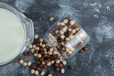 Cam kavanoz mısır gevreği ve mermer zemin üzerinde taze süt.