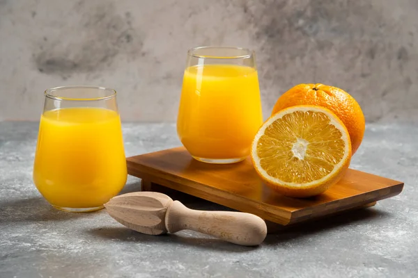 Скляні чашки апельсинового соку та дерев'яний репер — стокове фото