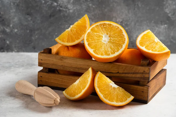 Нарізані свіжі апельсини з дерев'яним репером на мармуровому фоні — стокове фото