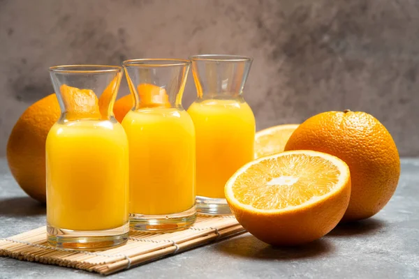 Скляні банки апельсинового соку і нарізаний апельсин — стокове фото