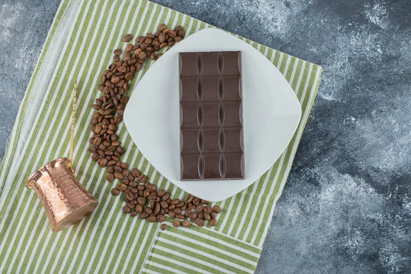 Bar de chocolate com grãos de café em uma toalha de mesa — Fotografia de Stock