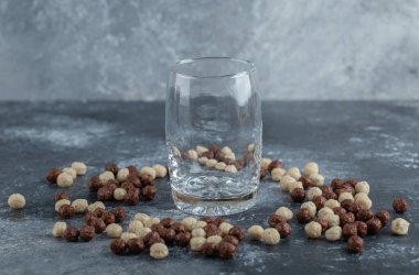 Boş bardaklara saçılmış mısır gevreği topları.