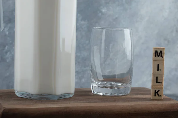 Caraffa di latte e bicchiere d'acqua su tavola di legno — Foto Stock