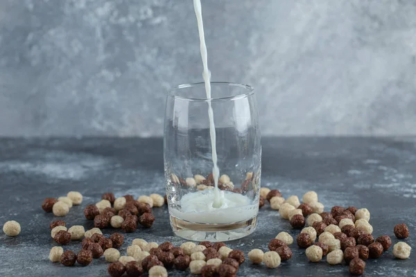 Verter la leche en un vaso sobre un fondo de mármol —  Fotos de Stock