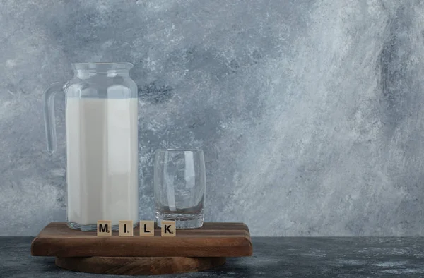 板の上の牛乳と水のガラスのジャグ — ストック写真