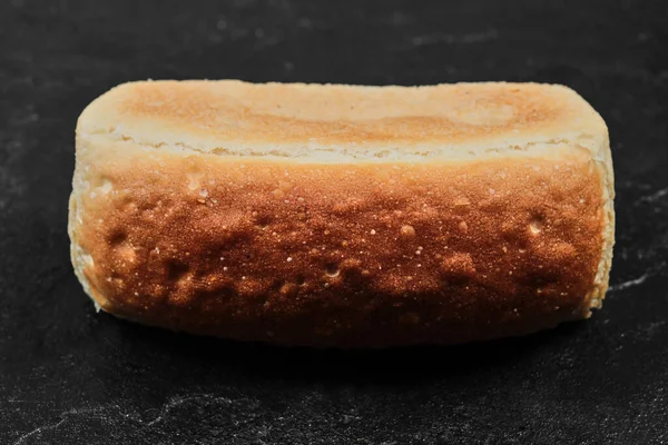 Pão quadrado isolado sobre fundo escuro — Fotografia de Stock