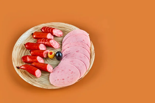 切碎的香肠放在盘子里，放在橙色的背景上 — 图库照片