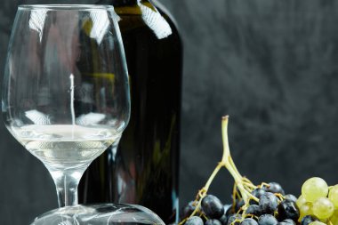 Bir demet üzüm ve siyah bir şişe şarap.