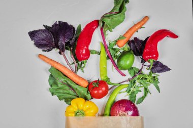 Taze sebzeler, havuçlar, biberler, yeşiller, havuçlar, kağıt torbada soğan.