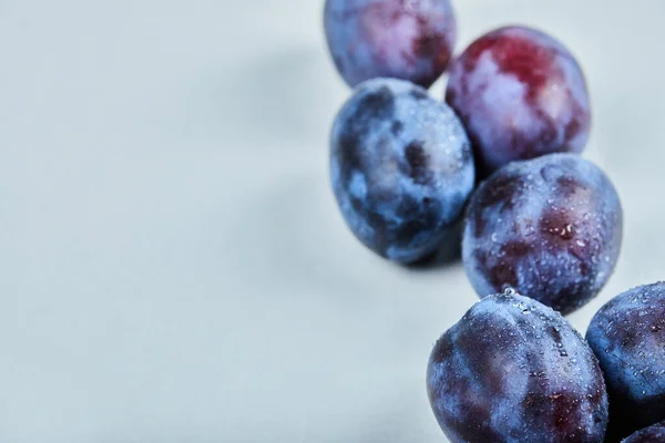 Groupe de prunes fraîches sur fond bleu — Photo