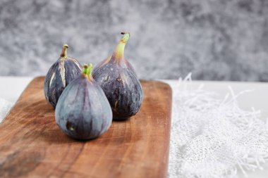 Mermer bir arka planda mor incir tabağı