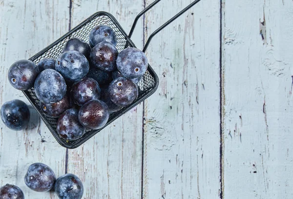 Prunes de jardin sur une table bleue — Photo