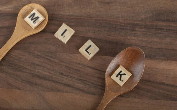 Holzbuchstaben buchstabiert als Milch auf Holzbrett — Stockfoto