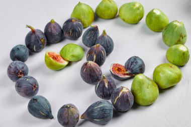 Mor ve yeşil incirler beyaz arkaplanda izole edilmiş