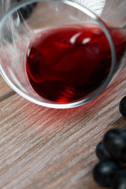 Ahşap masada bir kadeh kırmızı şarap.
