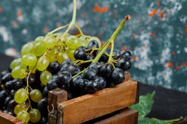 Tahta tepside yeşil ve kırmızı şarap demetleri