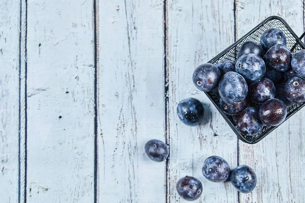 Prunes de jardin sur une table bleue — Photo