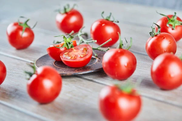 Hromada čerstvých šťavnatých rajčat a rajčat na dřevěném stole — Stock fotografie