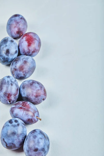 Groupe de prunes fraîches sur fond bleu — Photo