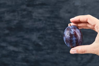 Koyu bir zeminde taze bir eriği tutan el.