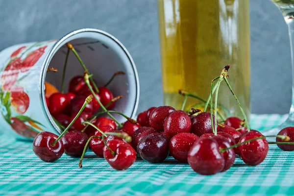 Copa de cerezas sobre fondo azul con vino blanco —  Fotos de Stock