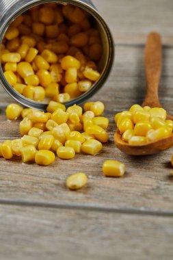 Tahta bir masada kaşıkla haşlanmış mısır konservesi.