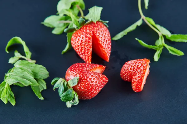 Frische rote Erdbeeren auf dunklem Hintergrund mit Blättern — Stockfoto