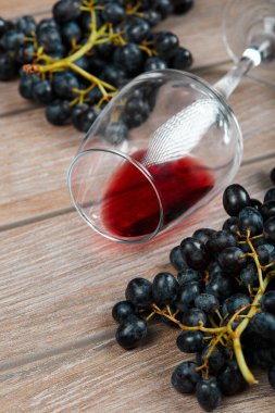 Bir bardak kırmızı şarap ve bir demet kırmızı üzüm.