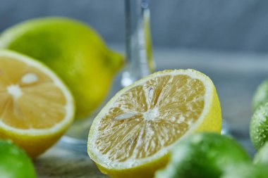 Yarım dilim limon ve mermer zemin üzerinde tuz olan kiraz erikleri.