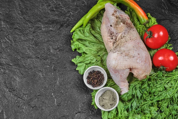 Rauwe kip op donkere achtergrond met verse groenten en specerijen — Stockfoto