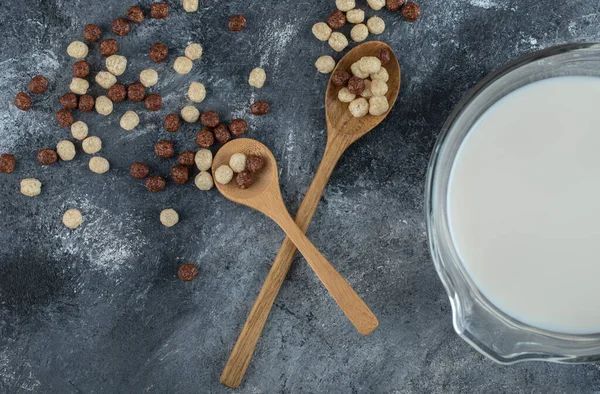 Bowl of milk and cereal balls on marble background