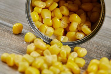 Tahta bir masada kaşıkla haşlanmış mısır konservesi.