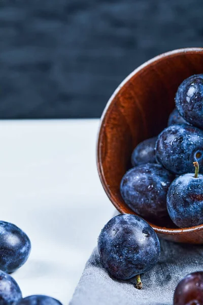 Bol de prunes de jardin sur fond blanc et sombre — Photo