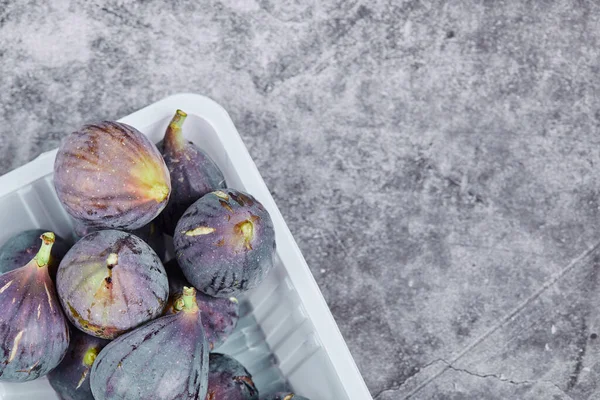 Figues violettes dans un récipient en plastique blanc — Photo