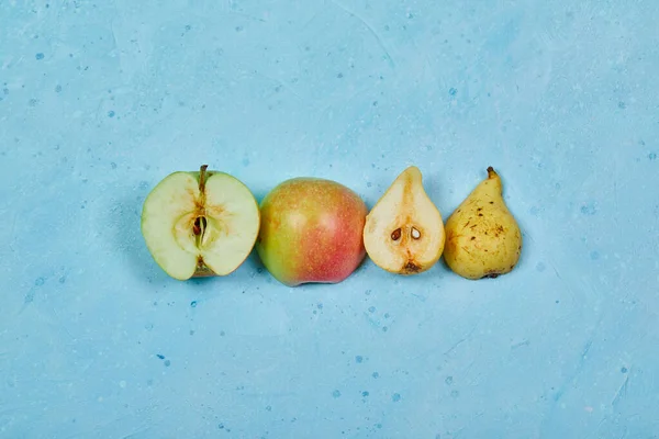 Demi coupé pomme et poire isolé fond bleu — Photo