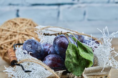 Tahta bir masada bir sepet taze erik.
