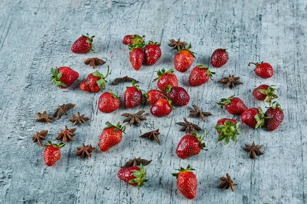 Frische rote Erdbeeren und Nelken auf Marmor-Hintergrund — Stockfoto