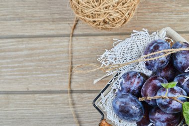 Bahçe erikleri ahşap bir masada sepetin içinde.
