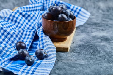Bahçe erikleri mermer bir arka planda bir kasede masa örtüsüyle