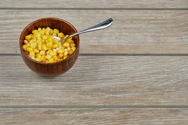 A bowl of boiled sweet corn on a wooden table — Stock Photo, Image