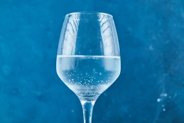 A glass of sparkling water on blue background — Stock Photo, Image